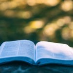An open Bible resting outdoors, symbolizing the Ten Commandments in Exodus 20 and God’s holy law for His people.
