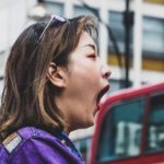 Person taking a deep breath in a busy city, illustrating how God gives breath and sustains us in every moment