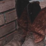 Worn boots by a brick wall, symbolizing trying to pull yourself up by your bootstraps when life feels bleak, reminding us to turn to the God of Hope