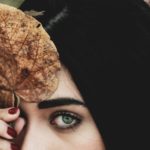Person partially hiding their face behind a leaf, illustrating the futility of hiding sin and the need to turn to God as our Hiding Place.