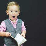 Young child holding an open Bible, reflecting on the wonder of Jehovah-Tsidkenu, the Lord our Righteousness.