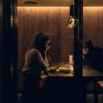 Woman praying in a quiet booth, reflecting on the Lord of Hosts who hears and delivers in fearful situations.