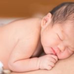 Sleeping baby resting peacefully, representing how God is quiet in love and holds us close in His tender care.