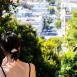 Image of a lady from behind looking out over a city, reflecting the desire to have someone watch your back and the comfort of trusting Jesus, the Guardian of Our Souls.