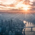 City at sunrise under the sky reflecting the authority of the Lord, the Father of Spirits, over all creation and life.