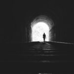 Person walking toward light through a dark tunnel, reflecting on Jesus, the prince of life, who conquered death and gives eternal hope.