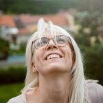 Woman looking upward with joy, reflecting on Jesus as the only Sovereign who is worthy of our praise, honor, and worship.