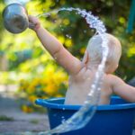 Child pouring water from a cup, illustrating the abundance of God as the Fountain of Life and the living water He provides.