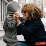 Mother protecting her child, illustrating the sacrificial love of Jesus as the Good Shepherd who laid down His life for us