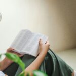 Person reading a Bible in quiet reflection, trusting the Faithful Creator in times of suffering.