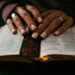 Hands resting on an open Bible, reflecting on what it means to worship a Jealous God above all else.