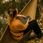 Woman resting in a hammock with a Bible, quietly reflecting on the comfort of the Holy Spirit as our Intercessor in prayer.