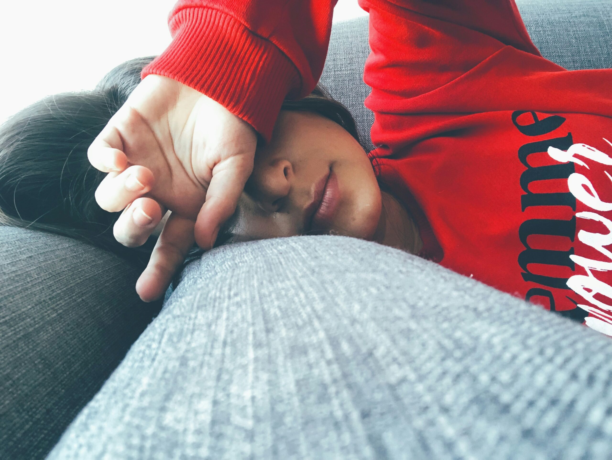 Woman lying on the couch, looking drained.