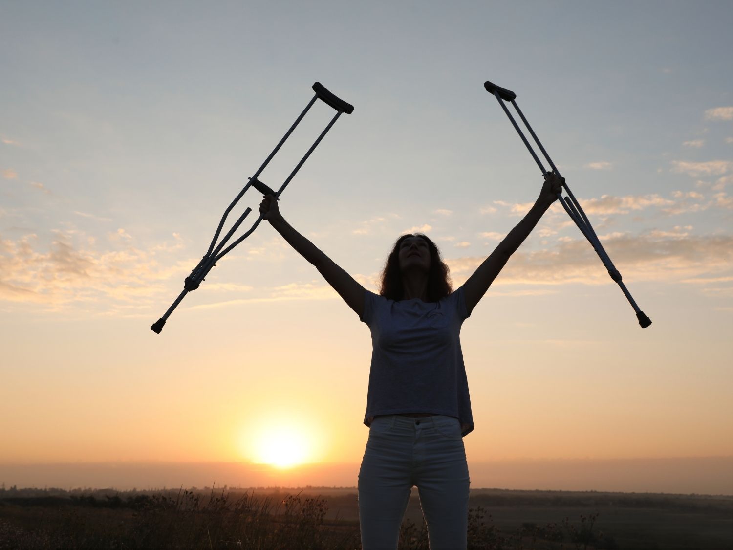 Women holding up crutches, a miracle