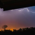 Lightning storm viewed from beneath shelter, illustrating how God is a shelter in life’s storms and a hiding place of peace and protection.