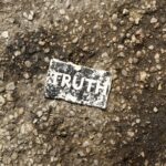 A distressed-looking card that says "TRUTH" on a road.