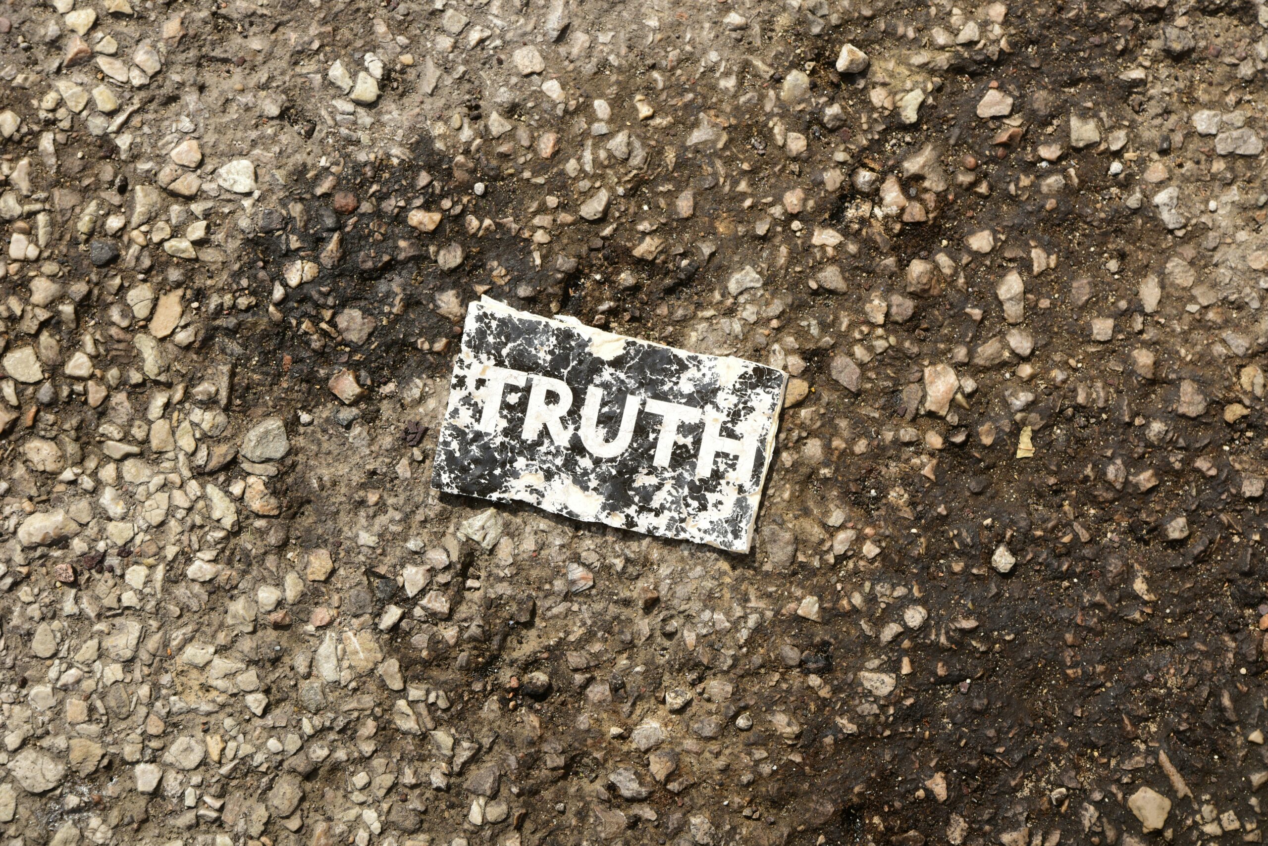 A distressed-looking card that says "TRUTH" on a road.