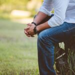 Person sitting with hands clasped, reflecting on uncertain times while trusting in God as the Highest One who reigns over all.
