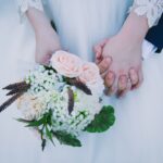 Bride and groom holding hands, symbolizing covenant love and reflecting God Our Husband’s faithful and lasting commitment to His people.