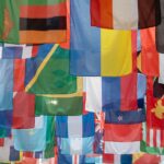 Colorful international flags representing many nations, reflecting on God as the King of the Nations who offers salvation through Jesus Christ.