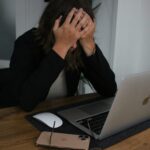 Woman overwhelmed at her desk, reflecting on the Lord of Sabaoth who sees, hears, and offers hope.