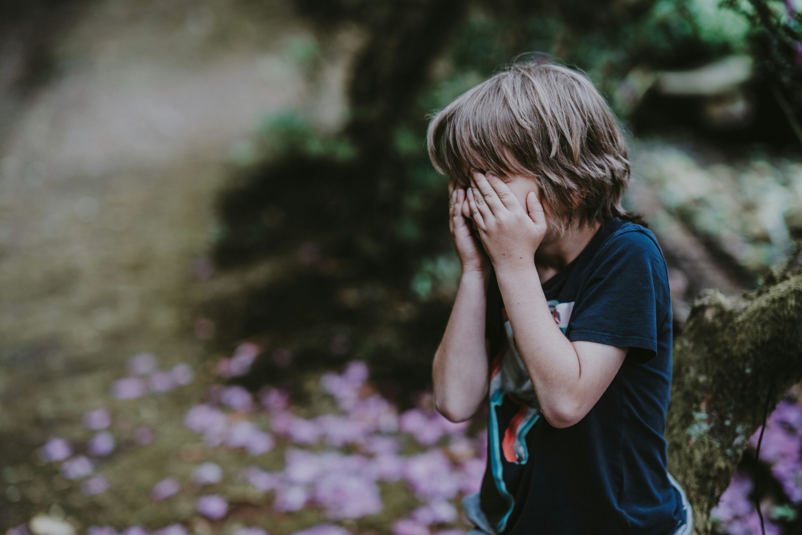 A child covering his eyes while playing hide and seek outdoors, illustrating the message of the Second Coming of Jesus and the need to be spiritually ready.