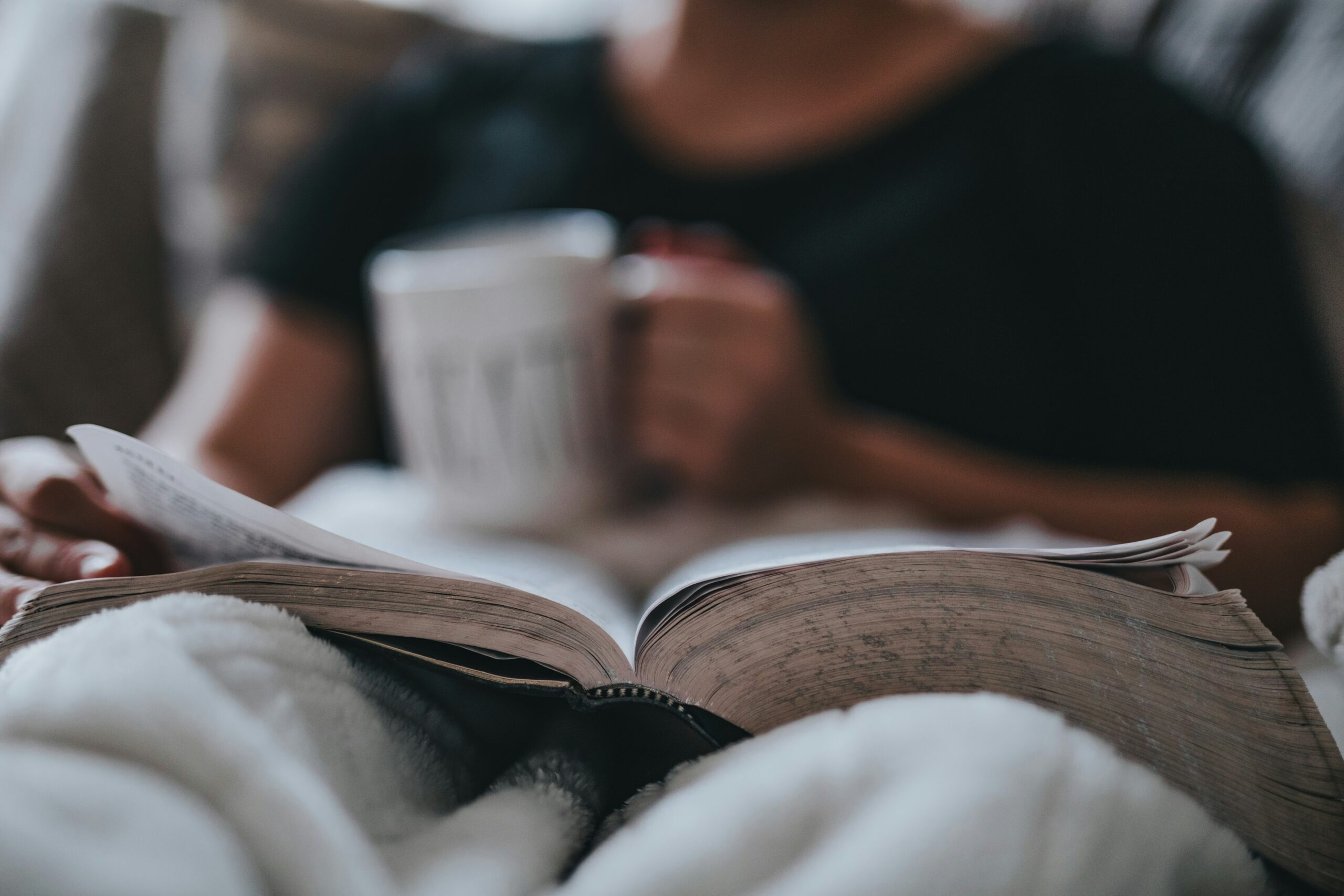 Person resting with an open Bible, illustrating how God is the restorer of my soul through His Word and presence.